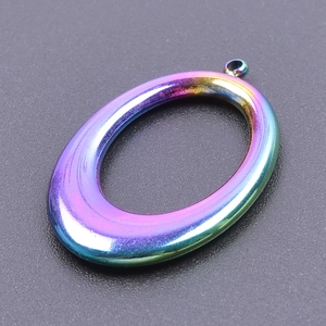 Macro detail of oval rainbow plated stainless steel pendant with iridescent metallic finish