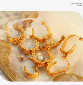 Macro shot of 18K gold plated stainless steel lava earrings on iridescent mother of pearl