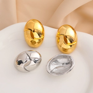 Pendientes ovalados bañados en oro de 18K y plata sobre un plato de cerámica