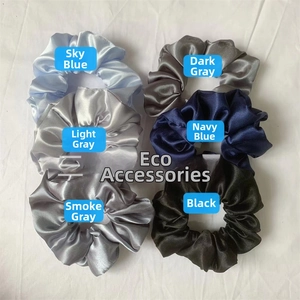 Set of six satin scrunchies in various shades of blue and grey on a white cloth backdrop