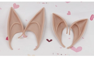Flat lay view of two pairs of beige soft silicone elf ears on a heart pattern background