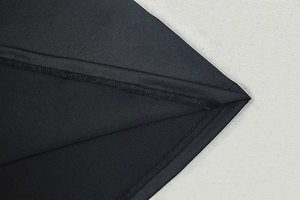 Detailed view of the double-stitched seam on a black sleeveless dress fabric