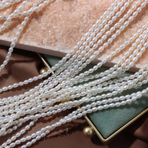 Lustrous 4mm white freshwater rice pearls on pink crystal and green velvet box