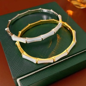 Detail of gold and silver bamboo style bangles with white shell inserts on jewelry box