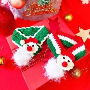Detail of red and green knitted Christmas scarves for pets on festive gift box