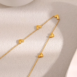 Close-up of golden 18K gold plated stainless steel O-chain featuring dainty heart pendants