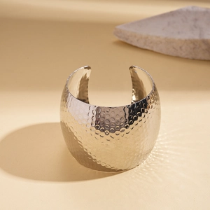 Detail of silver textured metal bangle with hammered finish on natural stone