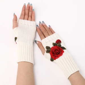 Detail of white knitted fingerless glove featuring a red 3D rose flower embroidery