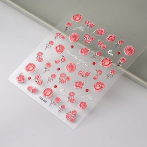 Detailed view of 5D embossed pink rose nail stickers with silver edges and floral patterns