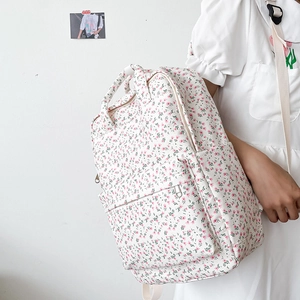 Detailed view of floral canvas backpack with pink flowers on cream white fabric