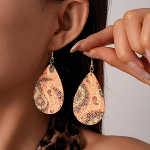 Gros plan de boucles d'oreilles en liège en forme de goutte avec motif paisley
