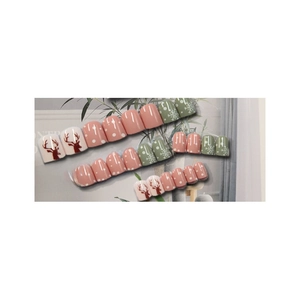 Short Christmas press-on nails featuring reindeer, snowflake patterns and dots in pink and green