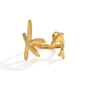 Détail d'une bague dorée ajustable avec étoile de mer et dauphin sur fond blanc