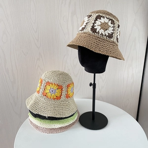 Detailed view of handmade crochet straw hat featuring retro colorful floral granny square patterns