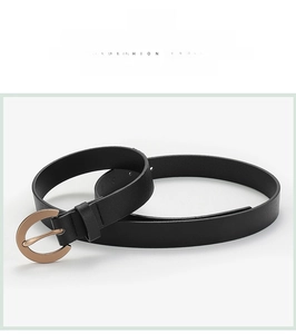 Macro detail of black leather belt with a polished round rose gold alloy pin buckle