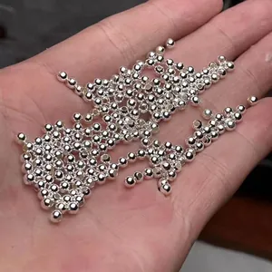 Polished S999 sterling silver beads for DIY jewelry making held in hand for scale