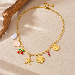 Gold stainless steel necklace with starfish, cherry and heart pendants on sand stone background