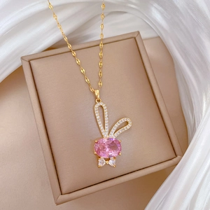 Détail d'un pendentif lapin doré avec une pierre rose et des micro-diamants scintillants