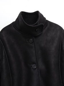 Detail of black faux suede jacket collar with thick white faux shearling lining and buttons