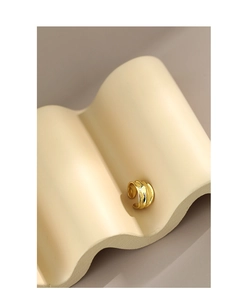 Detailed close-up of a minimalist golden multi-layer wave textured ear cuff earring
