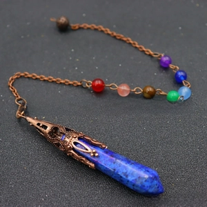 Detail of blue hexagonal crystal pendant with chakra beads and vintage copper cap