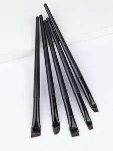 Macro shot of 5 professional angled eyeliner brushes with black matte handles and synthetic hair
