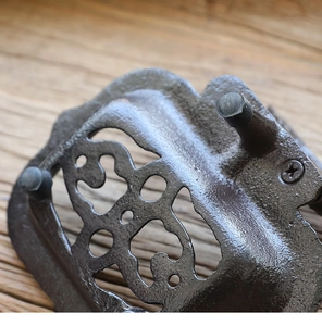 Close-up of vintage cast iron soap dish back featuring antique bronze hollowed-out details