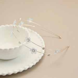 Detail of floral headband with blue fabric flowers and white pearls on rose gold wire