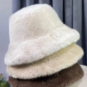 Detailed stack of soft plush bucket hats in white, beige, and dark brown colors
