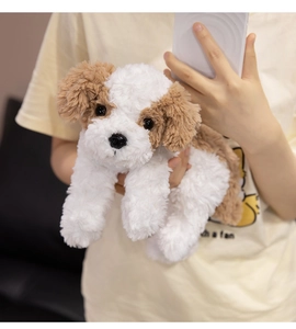 Close-up of soft plush puppy toy in white and light brown held by a person