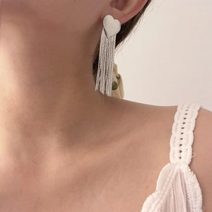 Elegant long silver tassel heart drop earrings for women shown on a model