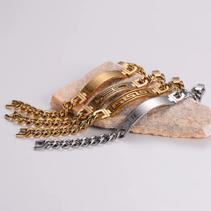 Gold and silver Cuban link chain bracelets with engraved Greek patterns on stone