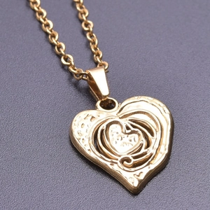 Detailed close-up of a 18k gold heart pendant with textured finish on a thick chain