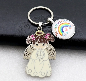 Close-up of Schulkind rainbow charm and angel pendant on a metal keychain