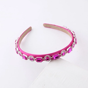 Detail of rose red satin headband with sparkling pink crystals in silver claw settings