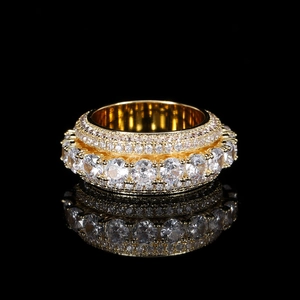 Macro shot of gold hip hop spinner ring with five rows of pavé zircons on black mirror