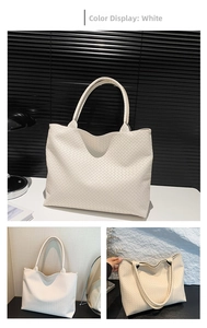 Close-up of intricate white woven texture and wide shoulder strap on the tote bag