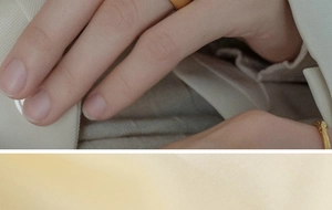Close-up of minimalist gold ring set featuring smooth band and irregular lava texture