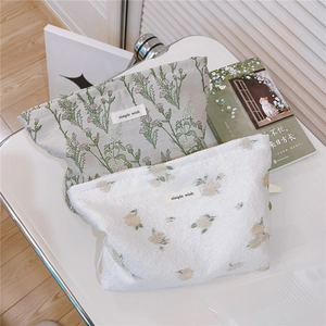 Close-up of floral fabric cosmetic bags with simple wish labels and zipper details