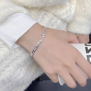 Classic S925 sterling silver Figaro chain bracelet on model wrist with lifestyle background