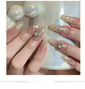 Detailed view of nude ballet nails with silver glitter, swirl lines and 3D heart diamonds
