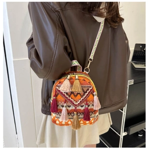 Ethnic style mini backpack with colorful woven patterns and tassel details on a model