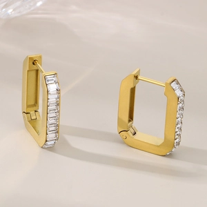 Detailed close-up of gold geometric earrings with rectangle-cut cubic zirconia inlay
