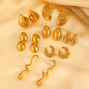 Modern gold geometric stainless steel earring set displayed on soft yellow silk fabric