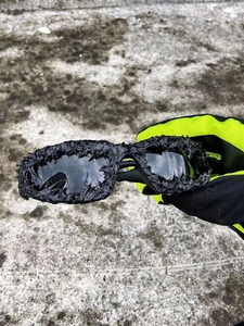 Detailed view of black avant-garde sunglasses with 3D lava texture and polarized lenses