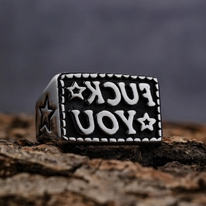 Retro stainless steel punk signet ring with engraved letters and star on bark background