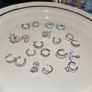 Silver ear cuff set with star and flower zircons on a white ceramic plate