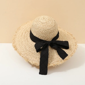 Summer straw sun hat for women with a black ribbon bow for seaside beach vacations