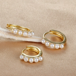Artistic 18K gold plated pearl hoop earrings displayed on premium golden silk fabric