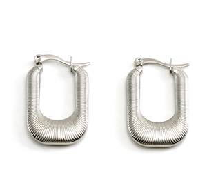 Macro detail of silver fluted U-shaped earrings with vertical ribbed metallic texture